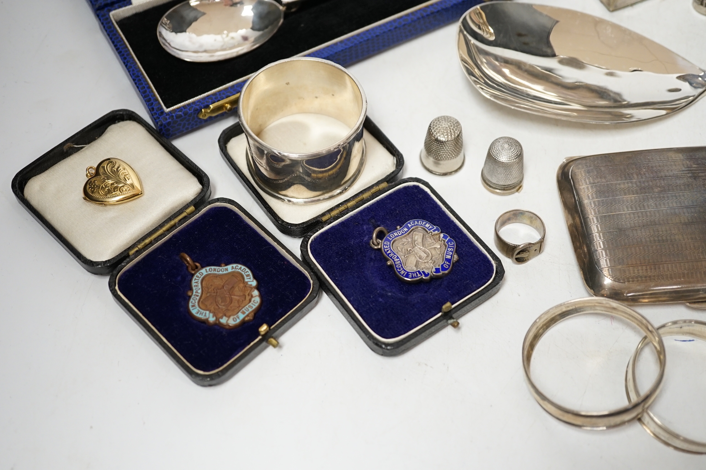 Sundry small silver including a cased preserve spoon, by Albert Edward Jones, a pair of mounted dwarf candlesticks, serving spoon, thimbles, napkin ring etc.